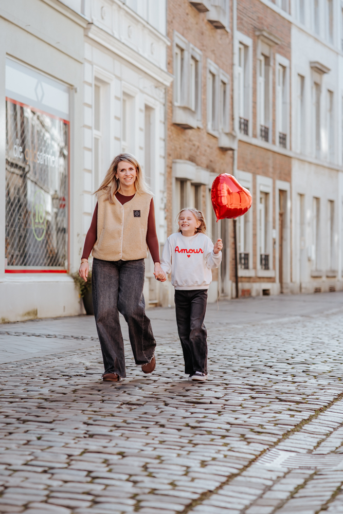 HOCHZEITSFOTOGRAFIN UND FAMILIENFOTOGRAFIN – MICHELLE 4 Mutter und Tochter laufen Hand in Hand durch Aachener Innenstadt mit Herzluftballon
